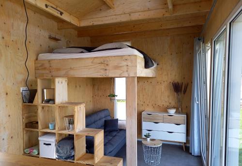 um quarto com um beliche numa casa de madeira em Tiny house het Polderhuisje em Streefkerk