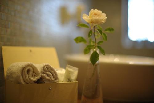 a flower in a vase next to a bathroom at B&B Le Dimore Mezza Costa in San Casciano in Val di Pesa