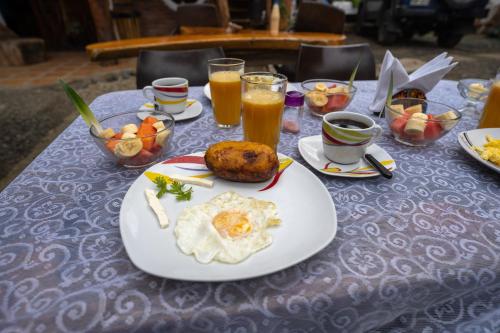 a table with a plate of breakfast food and drinks at Hostal Rutamar in Canoa