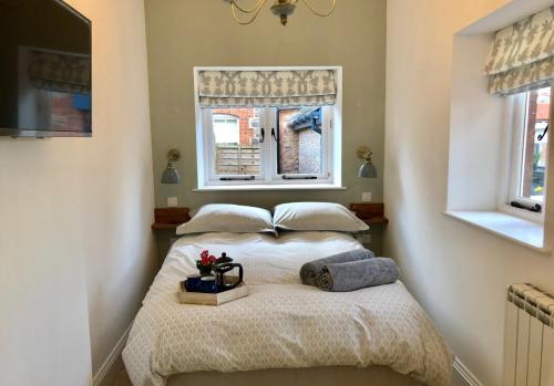 a bedroom with a bed with two pillows and a window at The Outhouse - Cosy Country Guest Suite in Kingston