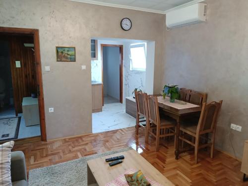 a living room with a table and chairs and a clock at Kuća za odmor DM in Bajina Bašta