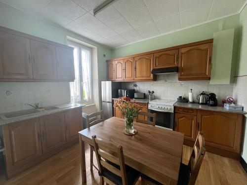 a kitchen with wooden cabinets and a wooden table at Centre ville - Maison chaleureuse - 6 pers in Châteaubriant