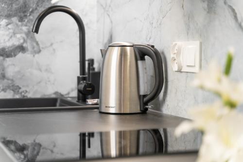 a kettle sitting on a kitchen counter next to a sink at Silver Apartments in Świnoujście