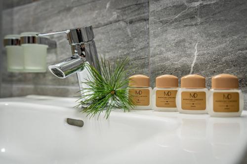 a row of four bottles of no smoking candles on a bathroom sink at Rezydencja Markowy Dworek in Białka Tatrzanska
