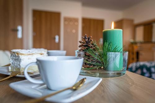 a table with a cup and a candle on it at Rezydencja Markowy Dworek in Białka Tatrzanska