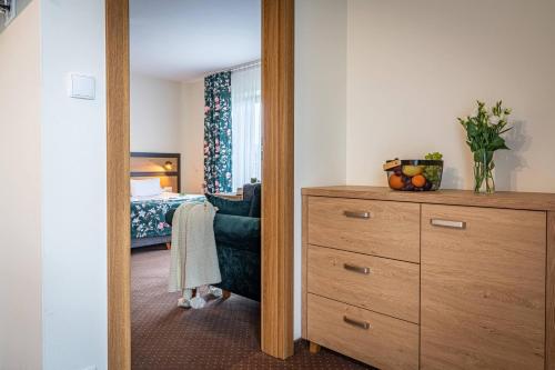a bedroom with a dresser and a bedroom with a bed at Rezydencja Markowy Dworek in Białka Tatrzanska