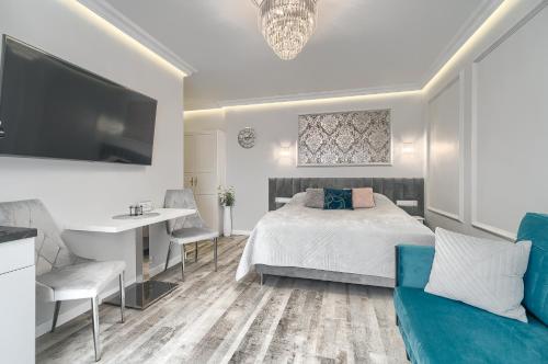 a bedroom with a bed and a desk and a tv at Silver Apartments in Świnoujście