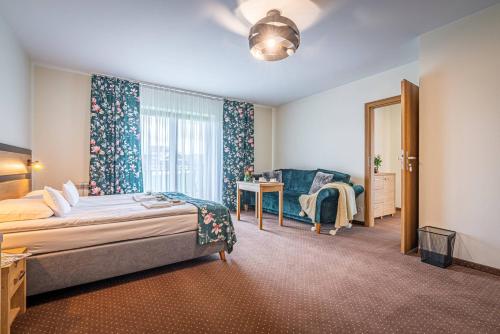 a bedroom with a bed and a chair and a window at Rezydencja Markowy Dworek in Białka Tatrzanska