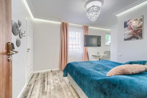 a bedroom with a blue bed and a bathroom at Silver Apartments in Świnoujście
