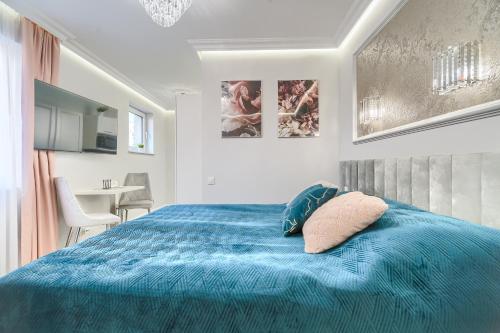 a bedroom with a blue bed and a dining room at Silver Apartments in Świnoujście