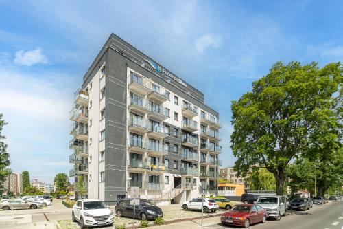 an apartment building on a street with parked cars at Silver Apartments in Świnoujście