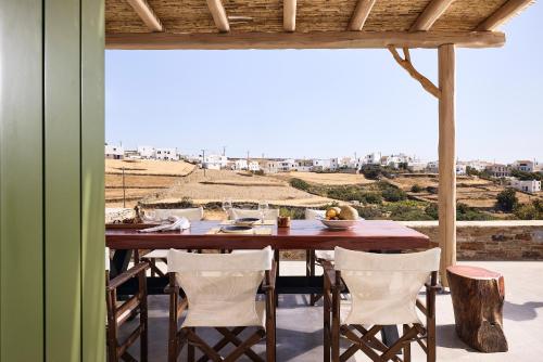 einen Tisch und Stühle auf einer Terrasse mit Aussicht in der Unterkunft Kozadinos Art Suites in Kythnos