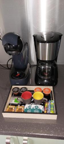 a counter top with a coffee maker and some food at Label kafé in Bouillante