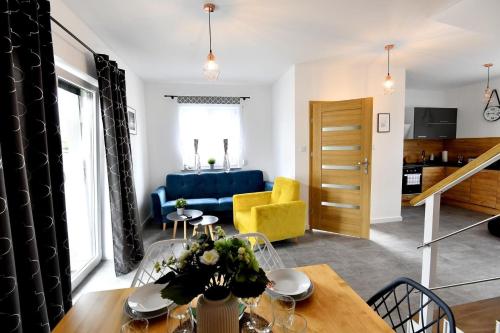 een woonkamer met een blauwe bank en een tafel bij Domki na Krótkiej in Spytkowice