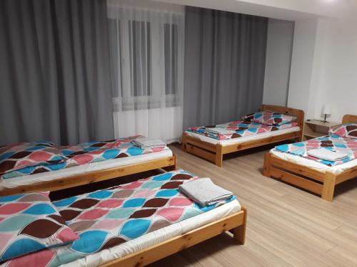 three beds sitting in a room with at Pokoje u Ludwika in Włodawa