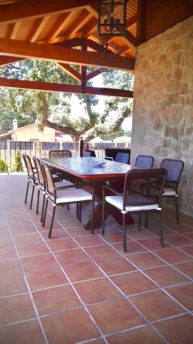 a wooden table and chairs on a patio at El Encinar in Maello