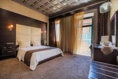 sypialnia z dużym łóżkiem i oknem w obiekcie Aion Luxury Hotel w Nauplionie