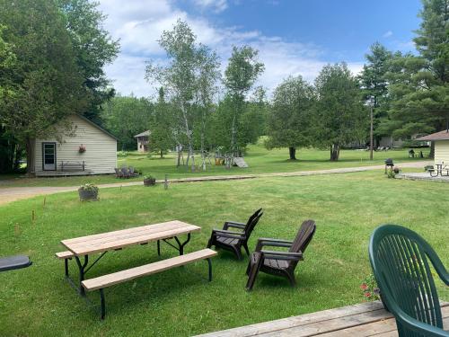 a picnic table and chairs in a park at Colonial Bay Motel and Cottages in Huntsville