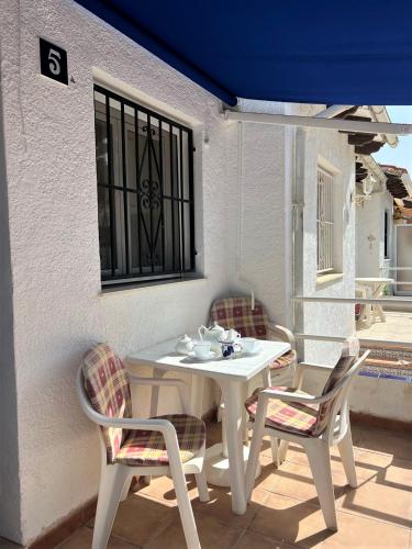 a white table and chairs on a patio at Vista Bahia II Apartments- top floor with balcony views & ground floor with garden and BBQ in Albir