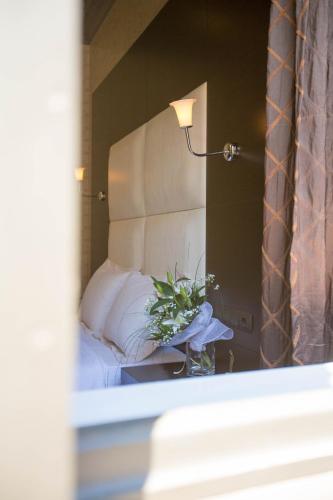 a bedroom with a bed with a mirror and a lamp at Aion Luxury Hotel in Nafplio