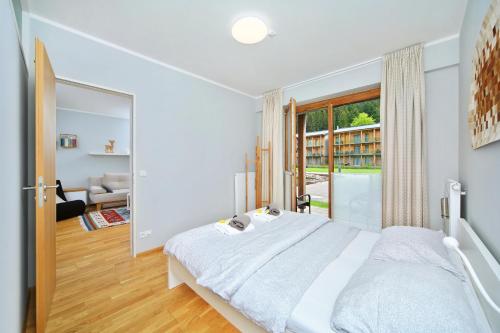 a bedroom with a large bed and a large window at Apartment Medvědín 331/409 in Špindlerův Mlýn