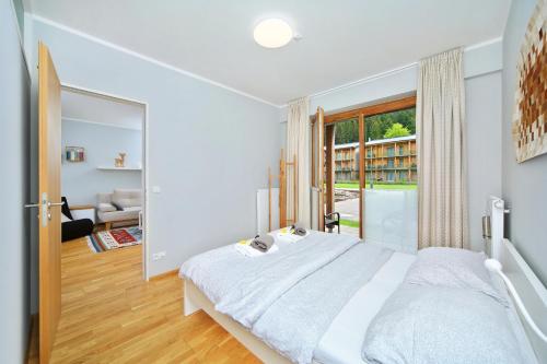 ein Schlafzimmer mit einem großen Bett und einem großen Fenster in der Unterkunft Apartment Medvědín 331/409 in Špindlerův Mlýn