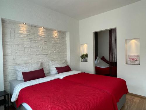 a bedroom with a large bed with a red blanket at Rose No 4 in Friedrichshafen