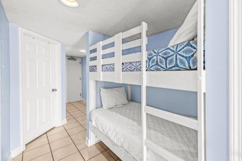 1 dormitorio con 2 literas y puerta blanca en Clearwater 8B en Gulf Shores