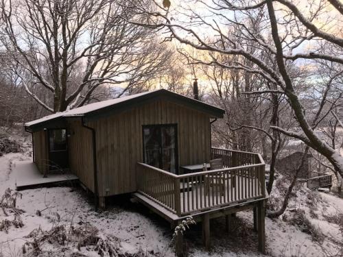a small wooden cabin in the snow with trees at Chapel House in Torridon