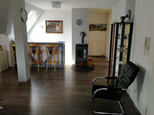 ein Wohnzimmer mit einem schwarzen Stuhl und einem Tisch in der Unterkunft Ferienwohnung Frankfurt in Neu-Anspach