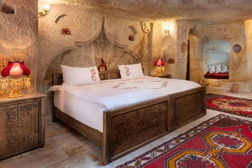 a bedroom with a large bed in a stone room at Kayata Cave Suites Special Class in Urgup