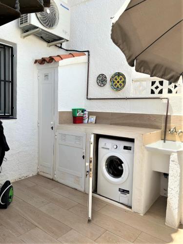 a washing machine in a laundry room with a sink at Vista Bahia II Apartments- top floor with balcony views & ground floor with garden and BBQ in Albir