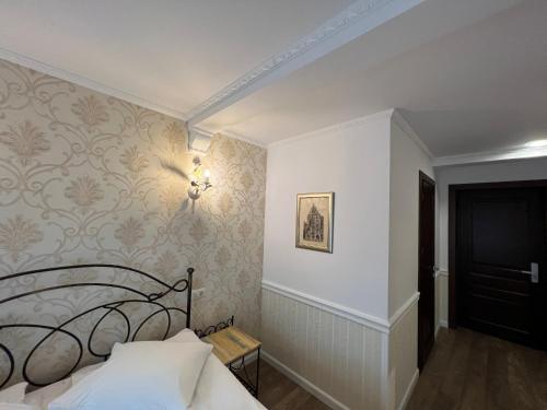 a bedroom with a bed and a wall with wallpaper at Hotel Boutique Cathedral Plaza Residences room for rent downtown in Bucharest