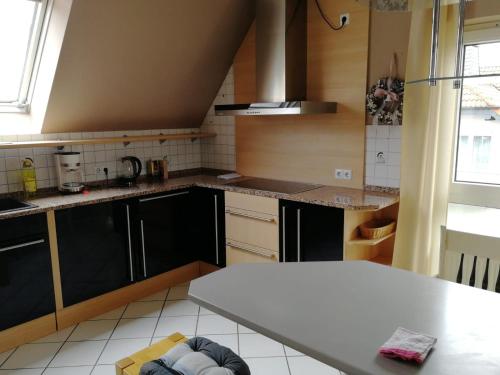 a kitchen with black cabinets and a white counter top at Ferienwohnung Frankfurt in Neu-Anspach