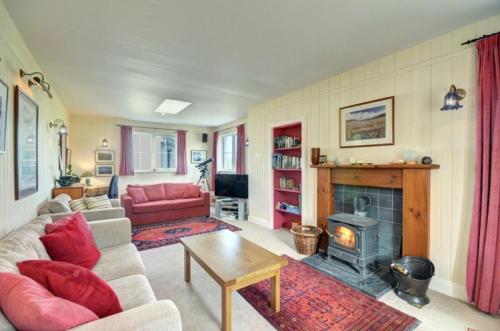 a living room with a couch and a fireplace at 7A Ardroil in Uig