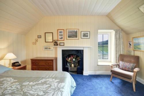 a bedroom with a bed and a fireplace and a chair at 7A Ardroil in Uig