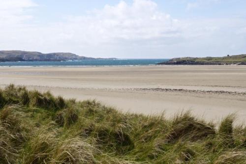 a beach with the ocean in the background and some grass at 7A Ardroil in Uig