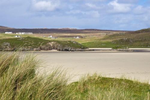a view of a beach with grass in the foreground at 7A Ardroil in Uig