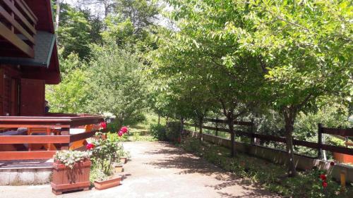 科拉欣的住宿－Crkvine Chalet，一条有鲜花和树木的围栏旁的小径