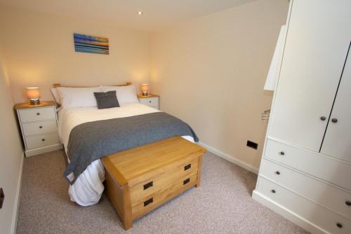 a bedroom with a bed and two night stands and a drawer at Braemore Chalet in Tarbert