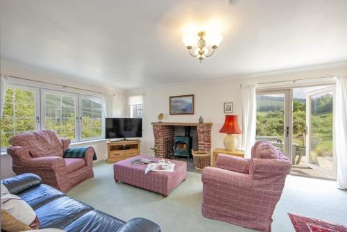 a living room with a couch and chairs and a fireplace at Branter Lodge in Strachur
