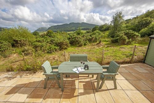 a table and chairs on a patio with a view at Branter Lodge in Strachur