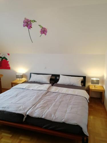 ein Schlafzimmer mit einem großen Bett mit zwei Tischen in der Unterkunft Ferienwohnung Frankfurt in Neu-Anspach