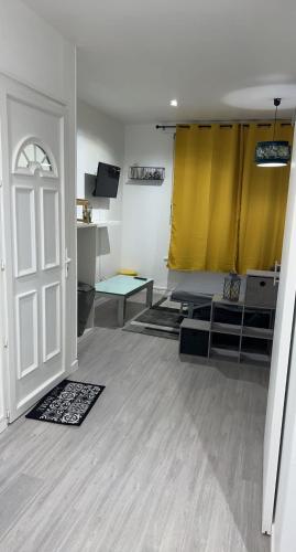 a living room with a yellow curtain and a door at Appartement moderne refait à neuf proximité centre ville et plage in Coudekerque-Branche
