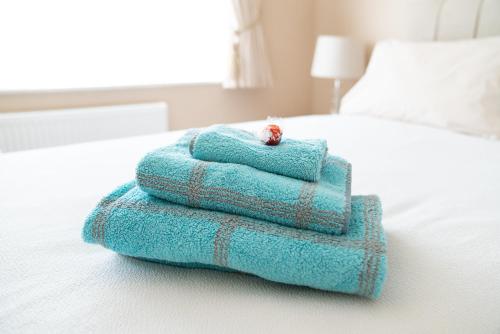 a stack of towels sitting on top of a bed at The Cedars in West Clandon