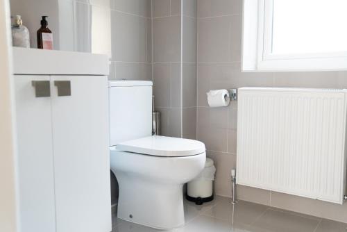 a bathroom with a white toilet and a window at The Cedars in West Clandon