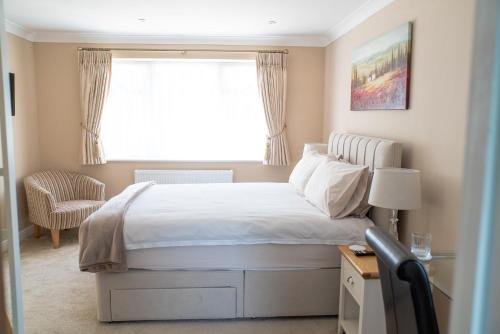 a bedroom with a large bed and a window at The Cedars in West Clandon