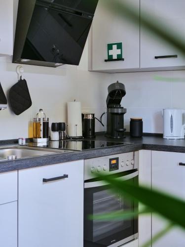 a kitchen with white cabinets and a stove top oven at Apartment SCHILLER I - Erfurt Zentrum in Erfurt