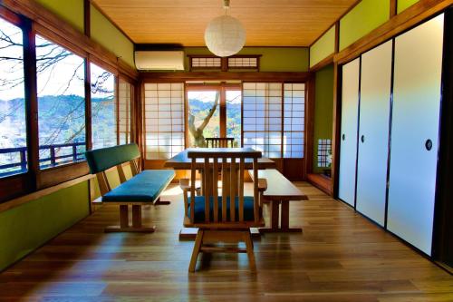una sala da pranzo con tavolo, sedie e finestre di En Yoshino - Vacation STAY 13165 a Kami-ichi