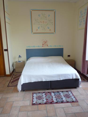 een slaapkamer met een bed en een tapijt op de vloer bij Appartamento palazzo del Provveditore vista lago in Desenzano del Garda